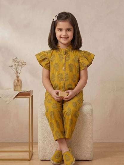 Girl sitting in mustard printed cotton co-ord set for summer outings