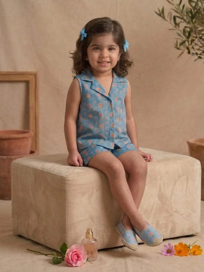 Toddler girl wearing blue pastel floral sleeveless co-ord set sitting pose
