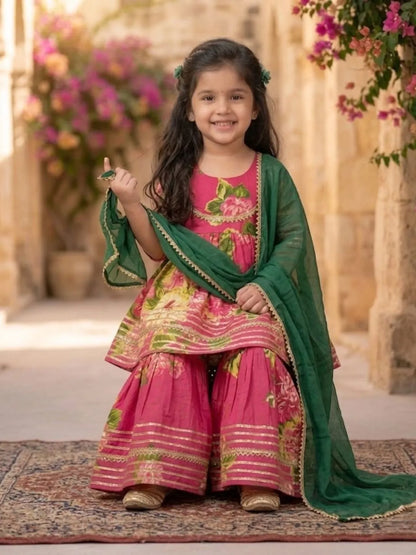 Girl sitting wearing pink floral sharara ethnic outfit