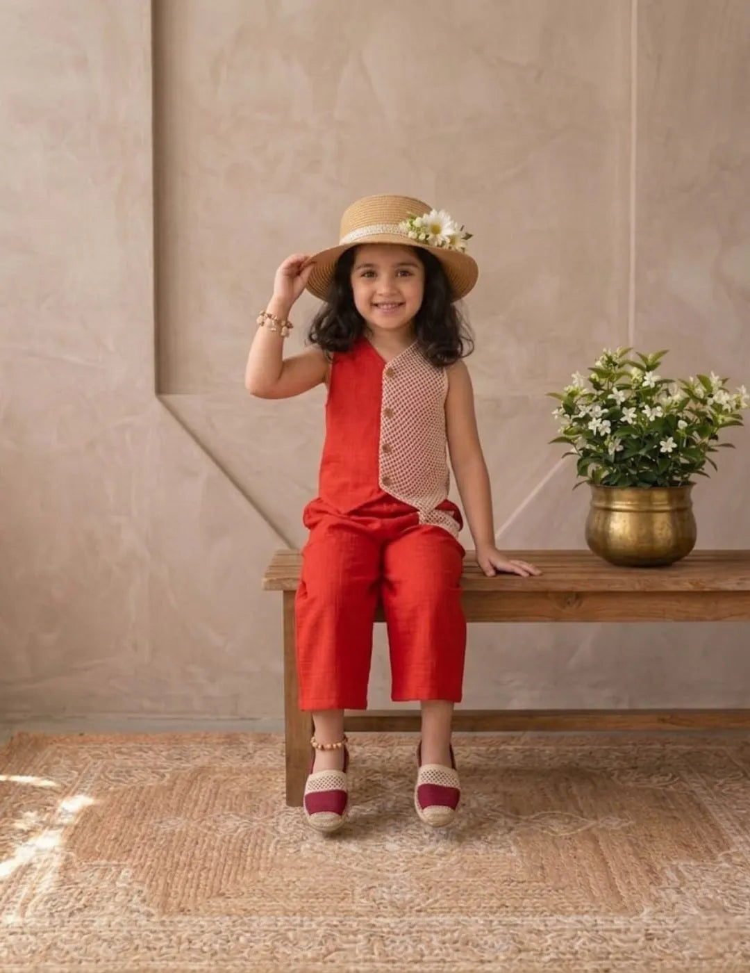 Full outfit look of girls red cotton co-ord set styled with hat and casual footwear