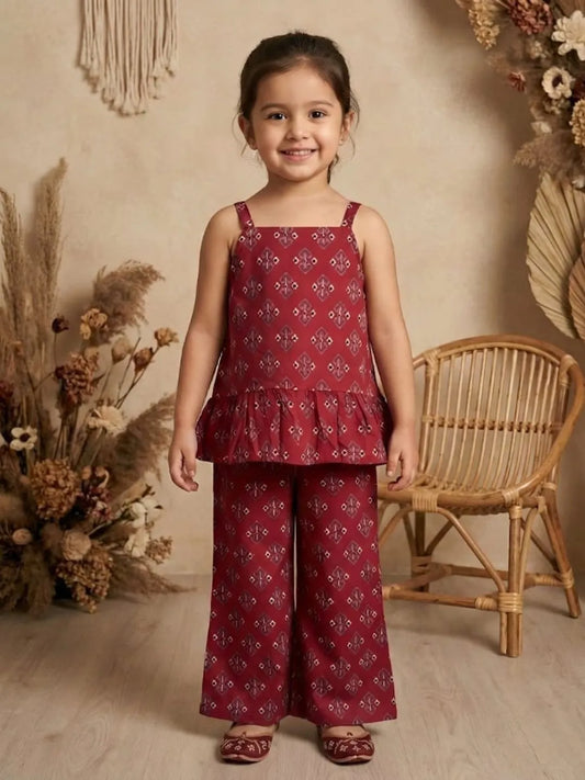 Girl wearing red printed co-ord set with sleeveless peplum top and wide leg pants front view