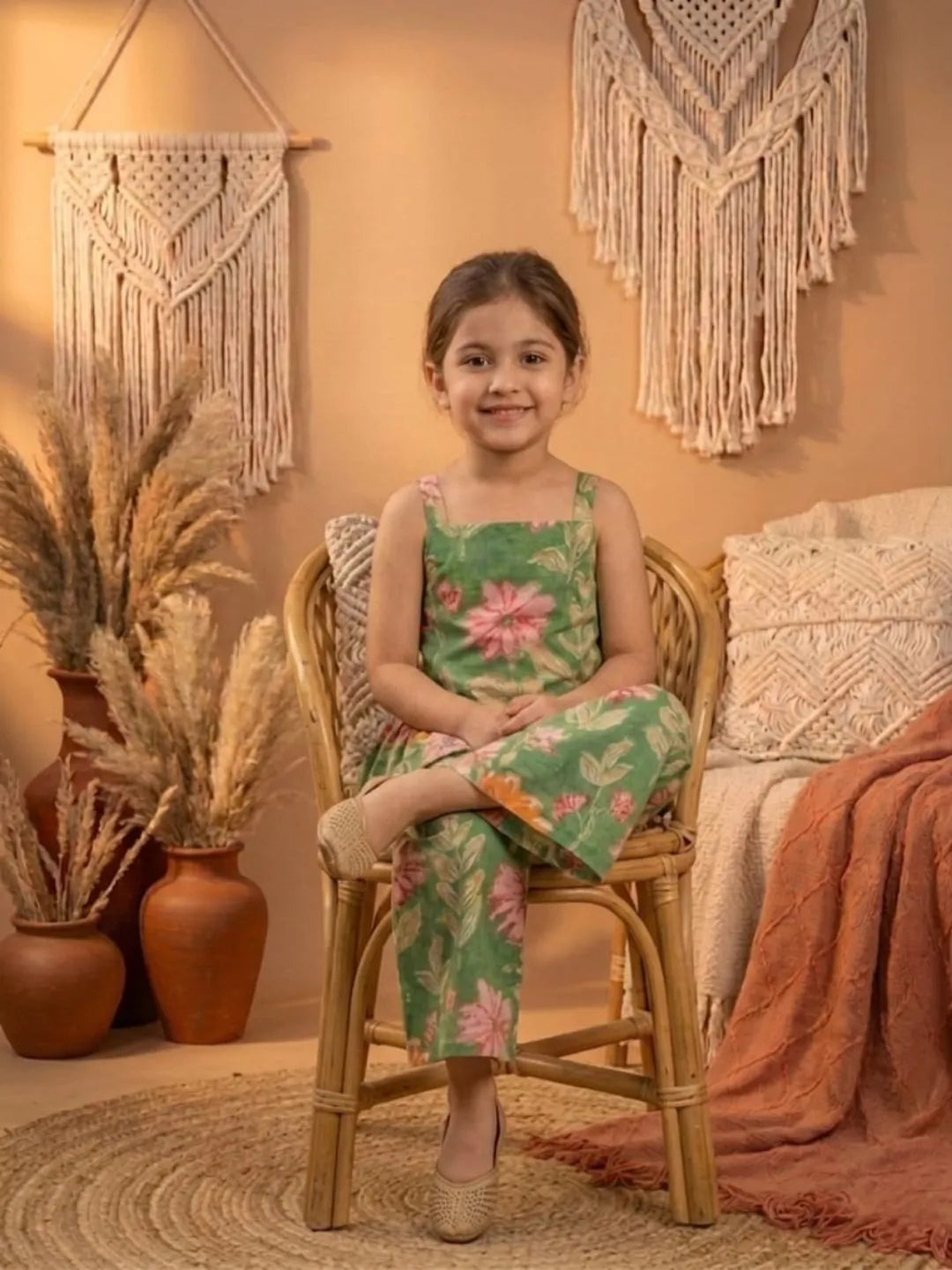 Girl sitting wearing green floral co-ord set with peplum top and wide leg pants