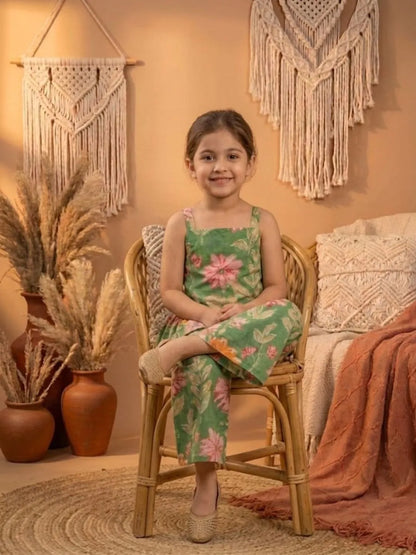 Girl sitting wearing green floral co-ord set with peplum top and wide leg pants