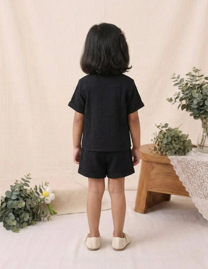 Back view of black cotton co-ord set with short sleeve shirt and matching shorts