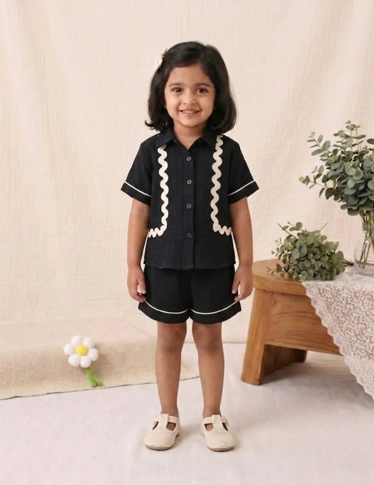 Kids black co-ord set front view with wavy detail shirt and matching shorts