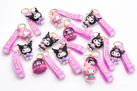 Collection of pink and black keychains with cartoon characters on a white background
