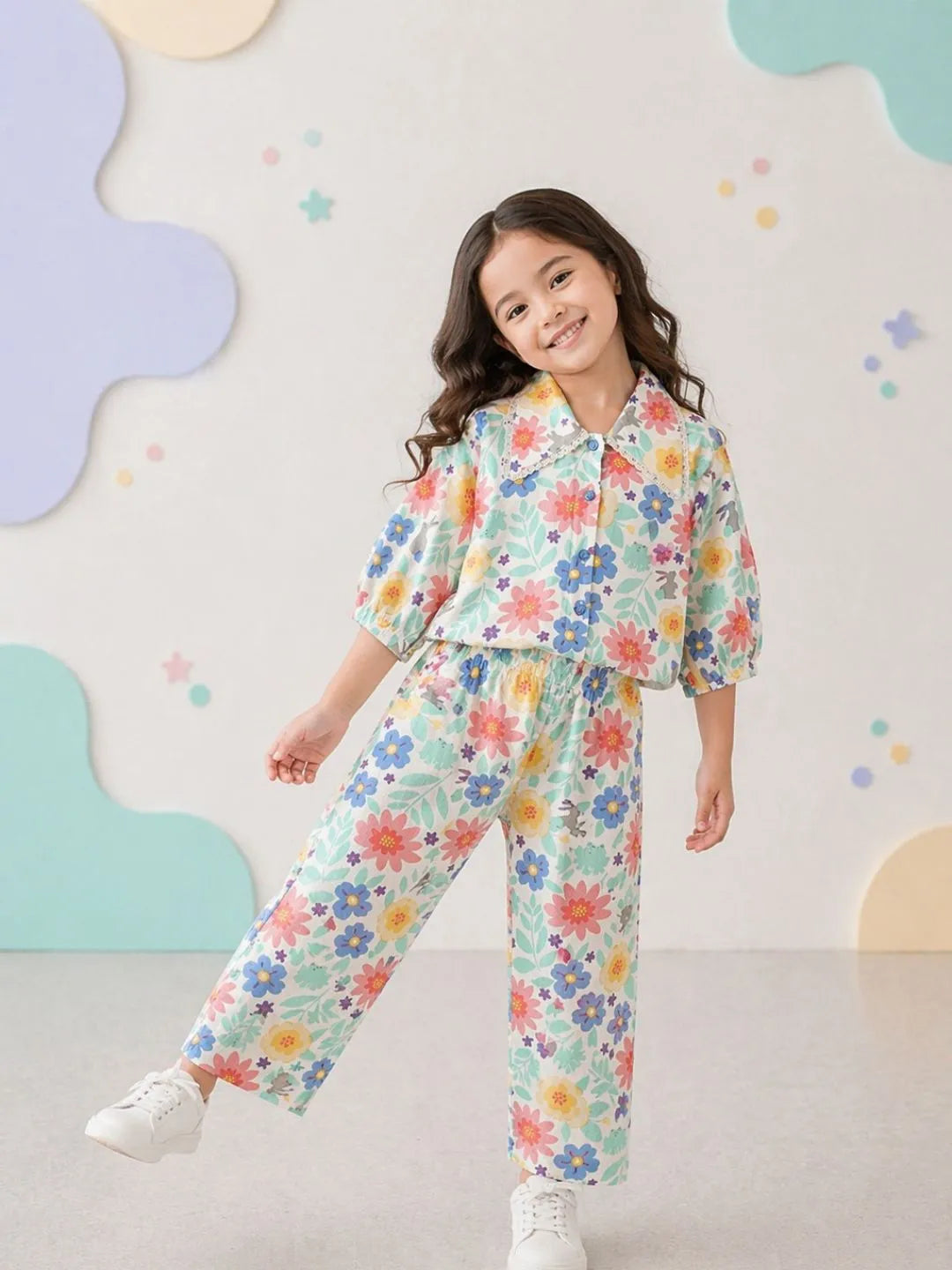 Young girl wearing a colorful floral outfit against a light background