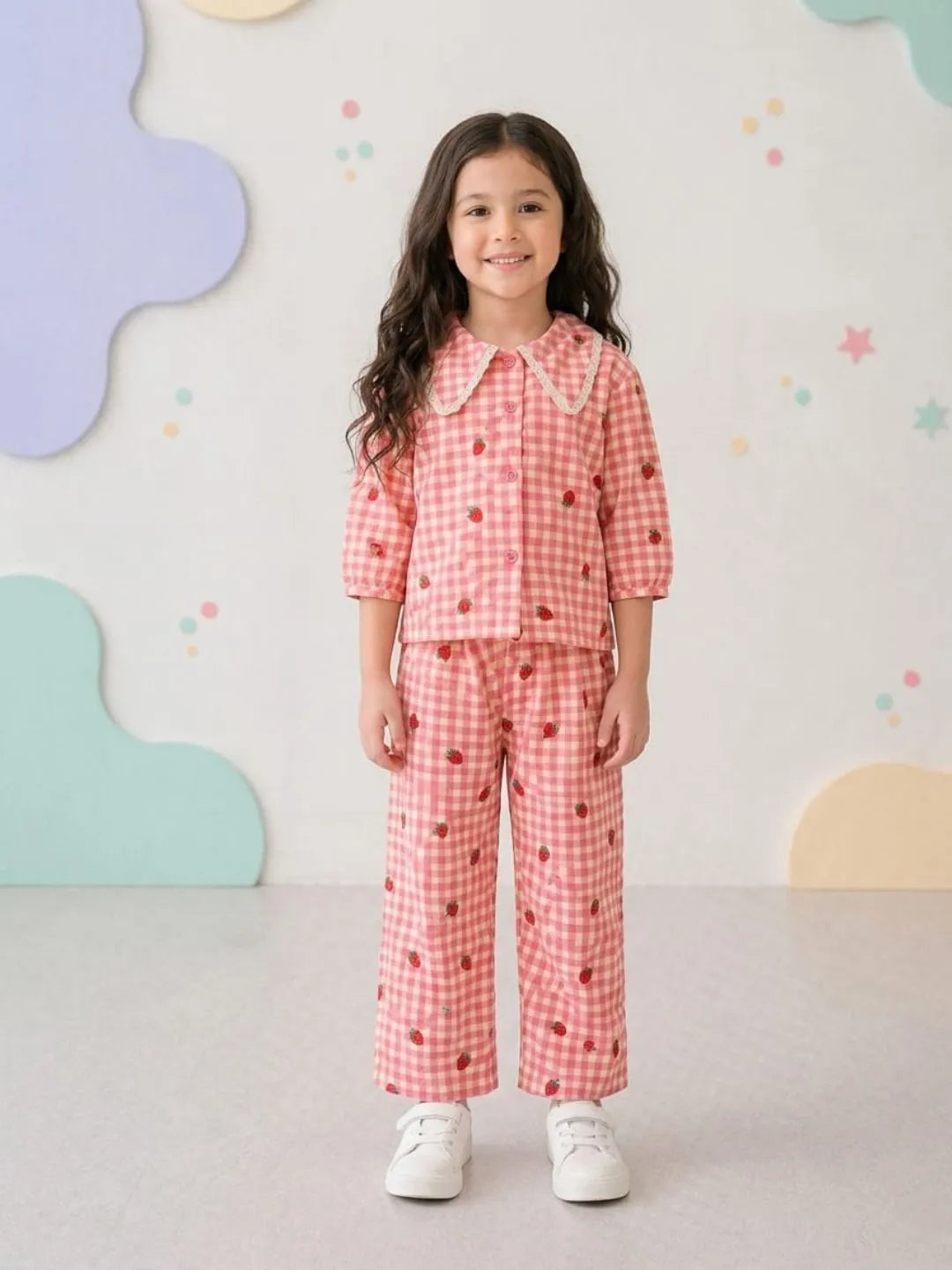 Young girl wearing a pink checkered outfit with a white background