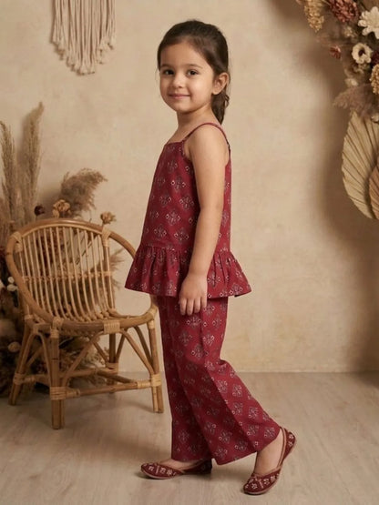 Side view of girls red printed co-ord set with sleeveless peplum top and wide leg pants