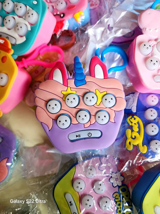 Colorful cartoon-like phone case with unicorn design on a pile of similar cases.